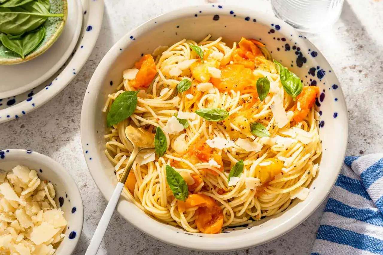 Szybki obiad z makaronem spaghetti, pomidorkami, bazylią i parmezanem. Idealny na letni posiłek.