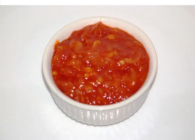 Czerwony sos piri piri w białej miseczce.